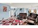 Cozy living room with comfortable leather seating, a unique area rug, and views of the staircase and kitchen at 1571 N Creekwater Pass, Greenfield, IN 46140