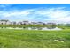 Scenic view of the community pond surrounded by lush green lawns, offering a tranquil and picturesque setting for residents at 1571 N Creekwater Pass, Greenfield, IN 46140