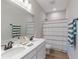 Modern bathroom features double sinks with white countertop, framed mirror, and striped shower curtain at 16067 Meadow Frost Ct, Fishers, IN 46037