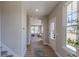 Inviting hallway with natural light and wood floors leads to the main living areas, showcasing a modern design at 16067 Meadow Frost Ct, Fishers, IN 46037