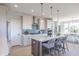 The kitchen boasts stainless appliances, white cabinets, teal backsplash, and an island with seating at 16067 Meadow Frost Ct, Fishers, IN 46037