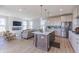 An open-concept kitchen with stainless steel appliances, a modern island, and beautiful hanging pendant lights at 16067 Meadow Frost Ct, Fishers, IN 46037