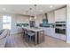 Modern kitchen features an island with seating, stainless appliances, white cabinets, and teal backsplash at 16067 Meadow Frost Ct, Fishers, IN 46037