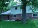 Backyard view of a two-story home with brick and siding, surrounded by lush greenery and a well-kept lawn at 1808 Orchid Ct, Indianapolis, IN 46219