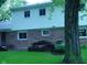 Back exterior featuring brick and siding, with a patio area and mature tree at 1808 Orchid Ct, Indianapolis, IN 46219