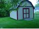 Outdoor shed with double doors, nestled in a green, grassy backyard at 1808 Orchid Ct, Indianapolis, IN 46219