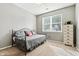 Neutral bedroom featuring a daybed, light-filled window, and a wooden dresser, ideal for relaxation at 19489 Prairie Crossing Dr, Noblesville, IN 46062