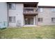 Condo backyard with light-gray and brick walls, small grass yard, and elevated dark-brown balcony at 209 Faulkner Ct # 102, Carmel, IN 46032