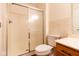 This bathroom features a stand up shower, toilet, wood cabinets, a sink, and tile flooring at 209 Faulkner Ct # 102, Carmel, IN 46032