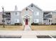 Inviting two-story condo building with a red front door and manicured landscaping at 209 Faulkner Ct # 102, Carmel, IN 46032