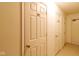 Hallway of condo with 3 white doors and the number 102 on one and a light colored floor at 209 Faulkner Ct # 102, Carmel, IN 46032