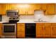 A view of the kitchen with stainless steel oven, black dishwasher, and light wood cabinets at 209 Faulkner Ct # 102, Carmel, IN 46032