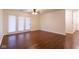 Open living room featuring hardwood floors, a ceiling fan, and doors to a patio at 209 Faulkner Ct # 102, Carmel, IN 46032