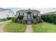 Charming home featuring a welcoming front porch, well-maintained lawn, and lush landscaping at 2249 Maple St, Columbus, IN 47201