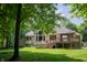 Expansive backyard featuring a deck, a hot tub, lush greenery, and a home with lots of windows at 23119 Sonoma Ln, Cicero, IN 46034