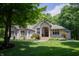 Charming brick home with manicured lawn, blooming flowers, and a covered front porch entrance at 23119 Sonoma Ln, Cicero, IN 46034