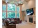 Cozy living room area featuring a fireplace, large windows, and a comfortable leather sectional at 23119 Sonoma Ln, Cicero, IN 46034