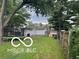 Large backyard with a fence, mature trees, trampoline, and an attached garage at 2412 Mars Hill St, Indianapolis, IN 46241