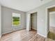 Bedroom featuring wood-look flooring, window with blinds, and closet at 2524 E 17Th St, Indianapolis, IN 46218
