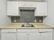 A kitchen featuring white cabinets and tan countertops, complemented by a stainless steel sink at 2524 E 17Th St, Indianapolis, IN 46218