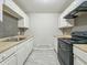 Compact kitchen featuring white cabinets, modern black hardware, and tile flooring at 2524 E 17Th St, Indianapolis, IN 46218