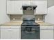 A kitchen showcases white cabinets, tan countertops, a black stove, and a tile backsplash at 2524 E 17Th St, Indianapolis, IN 46218