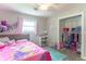 Playful bedroom showcasing a ceiling fan, window, and a tidy closet area at 2875 E Woodside Dr, Mooresville, IN 46158