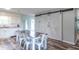 Dining room featuring wood-look floors, a rustic dining table, and decorative sliding barn doors at 2875 E Woodside Dr, Mooresville, IN 46158