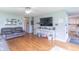 Spacious living room with hardwood floors, a large TV, and an open layout to the kitchen at 2875 E Woodside Dr, Mooresville, IN 46158