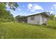 The backyard with grassy lawn, aged siding, brick foundation, and foliage at 31 Brooklyn Ct, Mooresville, IN 46158