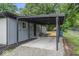 Attached carport with gravel flooring and a covered area offering convenient parking at 360 Richie Ave, Indianapolis, IN 46234