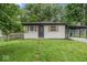 Well-maintained one-story home with gray brick, wood shutters, and a covered parking area at 360 Richie Ave, Indianapolis, IN 46234