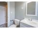 Well-lit bathroom with a white sink, mirror and toilet, complemented by neutral wall paint at 410 Plum St, Frankton, IN 46044