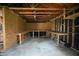 Unfinished garage interior with wooden beams and workbench offers potential for workshop or storage at 410 Plum St, Frankton, IN 46044