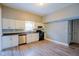 Bright kitchen with white cabinets, laminate floor, stainless steel dishwasher, and modern appliances at 410 Plum St, Frankton, IN 46044
