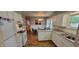 Open kitchen and dining area featuring white cabinets, stainless steel appliances, and hardwood floors at 420 Brookside Ln, Plainfield, IN 46168