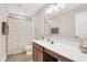A bright bathroom with a white countertop, wood cabinets, and a shower with a patterned curtain at 425 Weaver Ln, Pittsboro, IN 46167