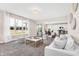 Bright and open living room featuring large windows, modern furniture, and seamless flow to the kitchen at 425 Weaver Ln, Pittsboro, IN 46167