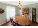 Warm dining room featuring a wooden table and chairs, china cabinet, and natural light from a window at 4329 Rutgers Dr # 40B, Anderson, IN 46013