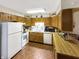 A functional kitchen featuring wood cabinets, white appliances, and plenty of counter space for meal preparation at 4329 Rutgers Dr # 40B, Anderson, IN 46013