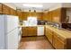 A functional kitchen featuring wood cabinets, white appliances, and plenty of counter space for meal preparation at 4329 Rutgers Dr # 40B, Anderson, IN 46013
