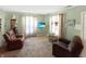 Cozy living room with comfortable armchairs, floral curtains, and a modern television display at 4329 Rutgers Dr # 40B, Anderson, IN 46013