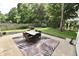 View of a patio with outdoor dining, a grill, and a leafy, green backyard at 44 Horseshoe Ln, Carmel, IN 46033