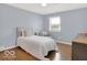 Comfortable bedroom featuring wood floors, accent chair, and natural light at 44 Horseshoe Ln, Carmel, IN 46033