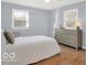 Cozy bedroom featuring wood floors, dresser, and natural light from two bright windows at 44 Horseshoe Ln, Carmel, IN 46033