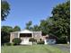 Lovely two-story brick home with attached garage surrounded by mature trees and lush green lawn at 44 Horseshoe Ln, Carmel, IN 46033