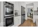 Modern kitchen featuring stainless steel appliances and sleek white cabinetry at 44 Horseshoe Ln, Carmel, IN 46033