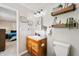 Bright bathroom with a single sink vanity, decorative shelving and decor, and a bedroom view at 453 N 275 E, Columbus, IN 47203