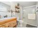 Bright bathroom with wood vanity, framed mirror, glass-enclosed shower, and tiled floors at 453 N 275 E, Columbus, IN 47203