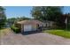 Aerial view of single-story home, attached garage, large gravel driveway, outbuilding, and mature landscaping at 453 N 275 E, Columbus, IN 47203